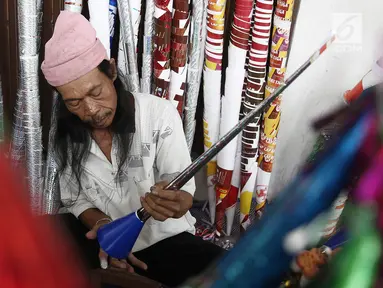 Pengrajin menyelesaikan pembuatan terompet di kawasan Glodok, Jakarta, Selasa (25/12). Menjelang tahun baru terompet konvensional tersebut dijual dengan harga dari Rp 5000 hingga Rp 10.000 tergantung ukuran dan jenisnya. (Liputan6.com/Herman Zakharia)