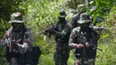 Prajurit TNI berpatroli sambil menenteng senjata saat latihan perang gerilya di Hutan Mata Ie, Banda Aceh, Aceh, Rabu (2/1). Latihan dilakukan untuk meningkatkan kemampuan prajurit TNI dalam menjaga keutuhan NKRI. (CHAIDEER MAHYUDDIN/AFP)
