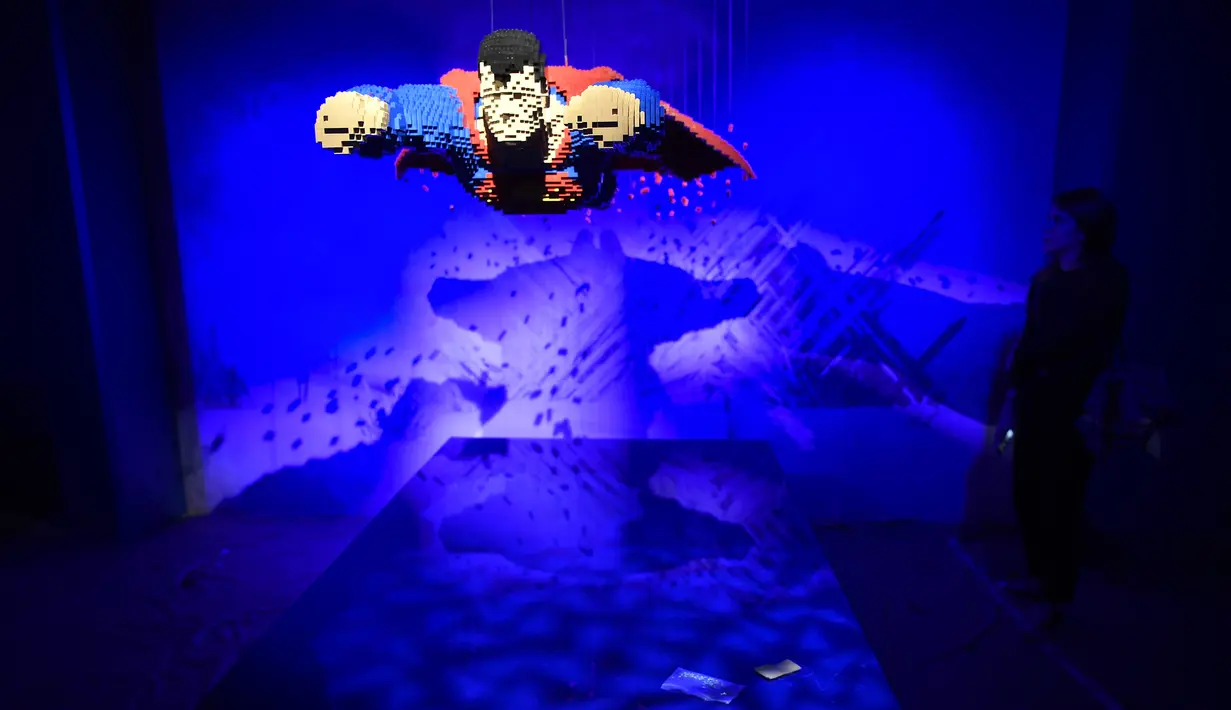 Seorang wanita berdiri dekat karakter pahlawan super dari DC yang dibuat dari Lego pada pameran Art of the Brick di La Vilette, Paris, Kamis (26/4). Tokoh superhero yang dibuat dengan Lego ini hasil karya seniman AS, Nathan Sawaya (AFP/Lionel BONAVENTURE)