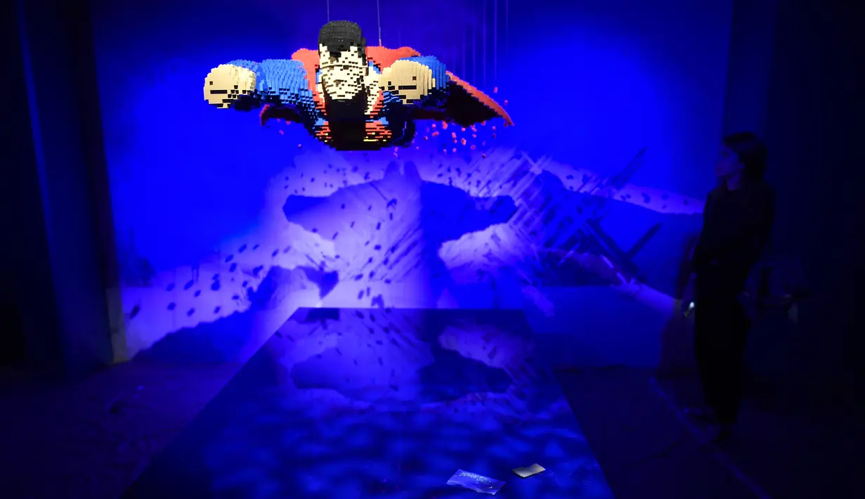 Seorang wanita berdiri dekat karakter pahlawan super dari DC yang dibuat dari Lego pada pameran Art of the Brick di La Vilette, Paris, Kamis (26/4). Tokoh superhero yang dibuat dengan Lego ini hasil karya seniman AS, Nathan Sawaya (AFP/Lionel BONAVENTURE)