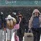 Para pemudik dalam rangka Imlek di China berjalan menerjang badai salju. (Photo: Chinatopix Via AP)