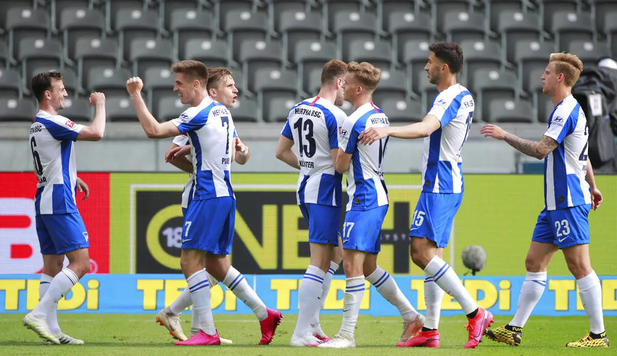 Para pemain Hertha Berlin merayakan gol yang dicetak oleh Krzysztof Piatek ke gawang Augsburg pada laga Bundesliga di Olympiastadion, Sabtu (30/5/2020). Hertha Berlin menang 2-0 atas Augsburg. (AP/Christof Stache)