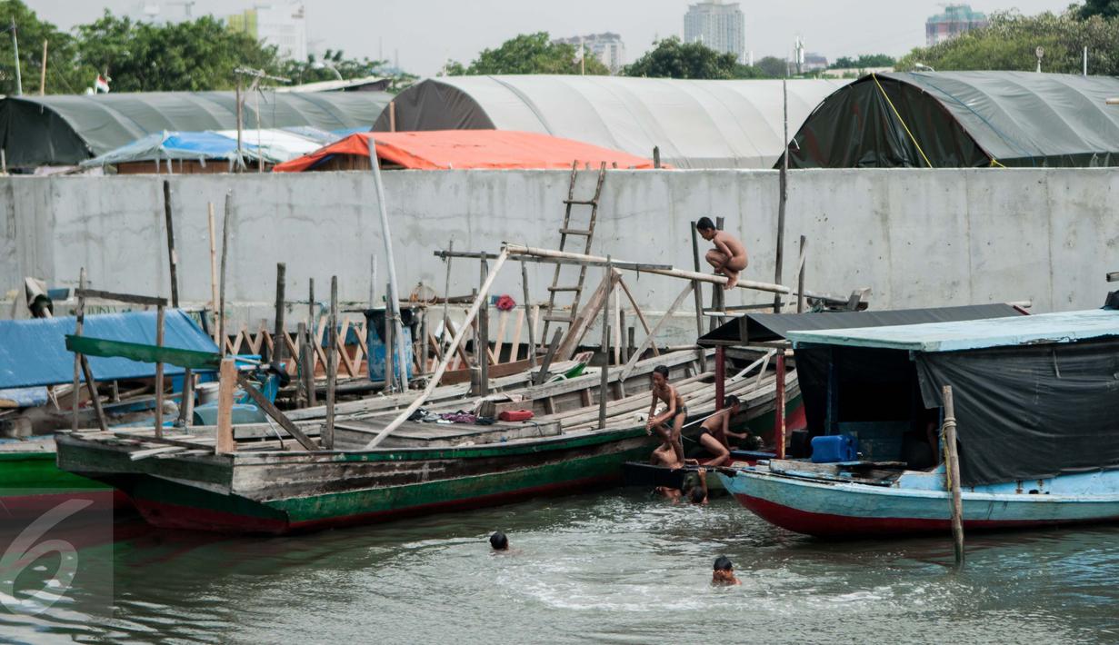 Anak-anak bermain di pantai Kampung Akuarium, Penjaringan, Jakarta Utara, Senin (30/1). Saat ini ratusan warga masih tinggal di lokasi yang telah digusur oleh Pemprov DKI. (Liputan6.com/Gempur M Surya)