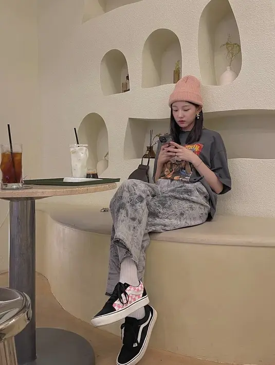 Cocok untuk hangout, padukan printed t-shirt dengan acid-wash jeans. Gaya jalanannya pun dipermanis dengan beanie dan sneakers warna senada. (Instagram/happy_yein).