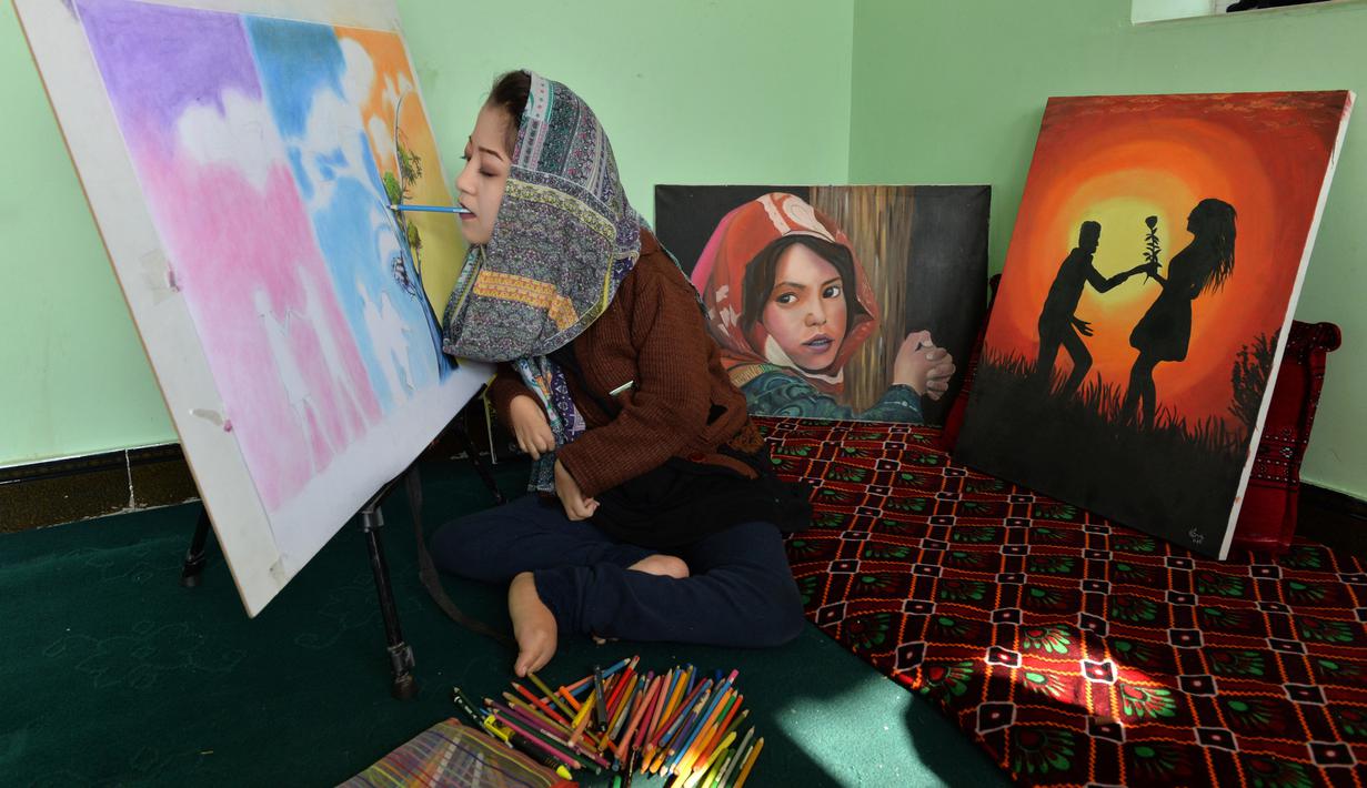 Seniman Robaba Mohammadi melukis dengan mulut di studionya di Kabul, 5 Desember 2019. Karya-karya Robaba telah dijual dan dipamerkan secara internasional dimana hasil penjualan lukisan membuatnya dapat meluncurkan pusat khusus untuk membantu melatih seniman difabel lainnya. (NOORULLAH SHIRZADA/AFP)