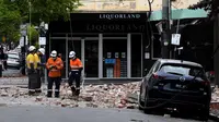 Petugas penyelamat memeriksa bangunan yang rusak setelah gempa magnitudo 5,8 di pusat perbelanjaan populer Chapel Street di Melbourne, Rabu (22/9/2021). Dilaporkan, warga Melbourne yang panik berlarian ke jalanan setelah guncangan gempa terasa di gedung-gedung. (William WEST/AFP)