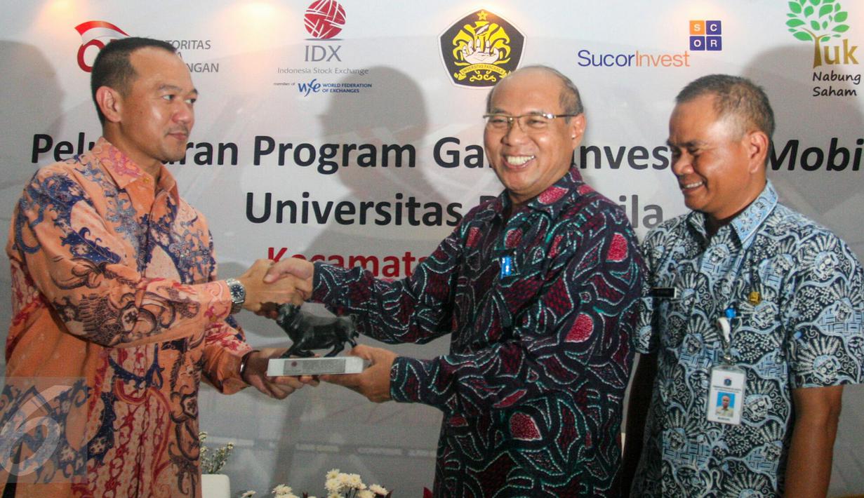 Direktur Pengembangan Bursa Efek Indonesia (BEI) Nicky Hogan (kiri) saat menerima cinderamata usai bersama Otoritas Jasa Keuangan (OJK) meluncurkan pilot project Galeri Investasi Mobile di Jagakarsa, Jakarta, Selasa (17/5). (Liputan6.com/Yoppy Renato)