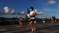 Orang-orang yang memakai masker berolahraga di sebuah taman di Hong Kong, Rabu (22/7/2020). Hong Kong menghadapi "tahap kritis" dalam perjuangannya melawan COVID-19, dan pemerintah sedang memperpanjang langkah-langkah baru untuk menjaga jarak sosial. (AP Photo/Kin Cheung)