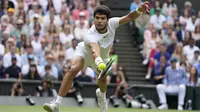 Petenis Spanyol, Carlos Alcaraz berusaha mengembalikan bola saat menghadapi petenis Serbia, Novak Djokovic pada laga final tunggal putra turnamen tenis Grand Slam Wimbledon 2023 di All England Lawn and Tennis Club, London, Minggu (16/7/2023) malam WIB. (AP Photo/Kirsty Wigglesworth)