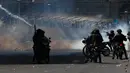Polisi antihuru-hara meluncurkan gas air mata untuk membubarkan demonstran saat ricuh dalam prosesi pemakaman orang yang tewas pada bentrokan antara pasukan keamanan dengan pendukung mantan Presiden Evo Morales di La Paz, Bolivia, Kamis, 21 November, 2019. (AP Photo/Juan Karita)