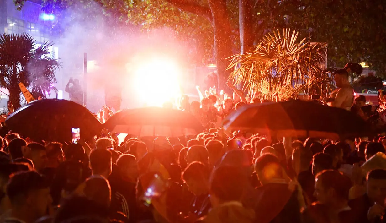 Ribuan suporter Skotlandia berkumpul dan menyalakan flare di Leicester Square di London, Jumat (18/6/2021). (AP/Alberto Pezzali)
