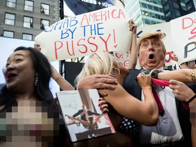 Seorang seninam berpenampilan seperti kandidat presiden AS dari Partai Republik Donald Trump melakukan aksi unjuk rasa dengan dikelilingi wanita-wanita seksi berbikini di depan Times Square, New York (25/10). (AFP Photo/Drew Angerer/Getty Images)