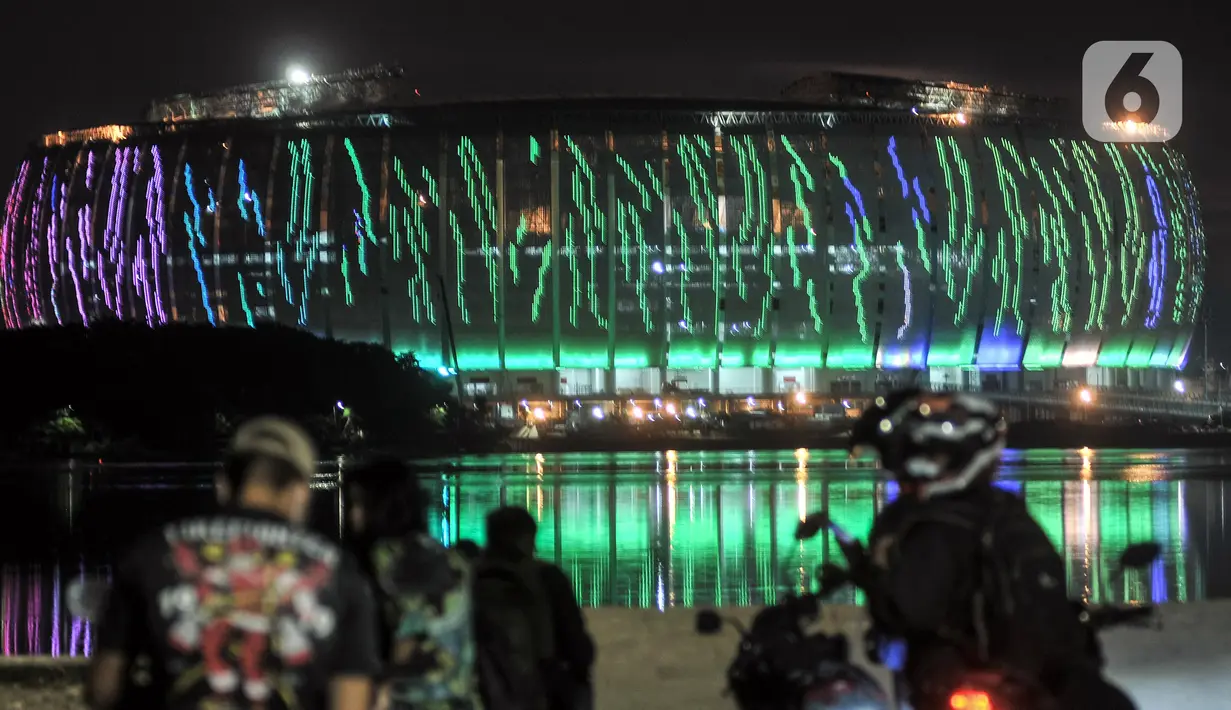 Warna-warni lampu Jakarta International Stadium (JIS) terlihat dari Waduk Cincin, Papanggo, Jakarta Utara, Rabu (16/3/2022). Gemerlapnya warna-warni lampu stadion kebanggaan Ibu Kota ini menjadi daya tarik warga yang melintas di kawasan tersebut. (merdeka.com/Iqbal S. Nugroho)