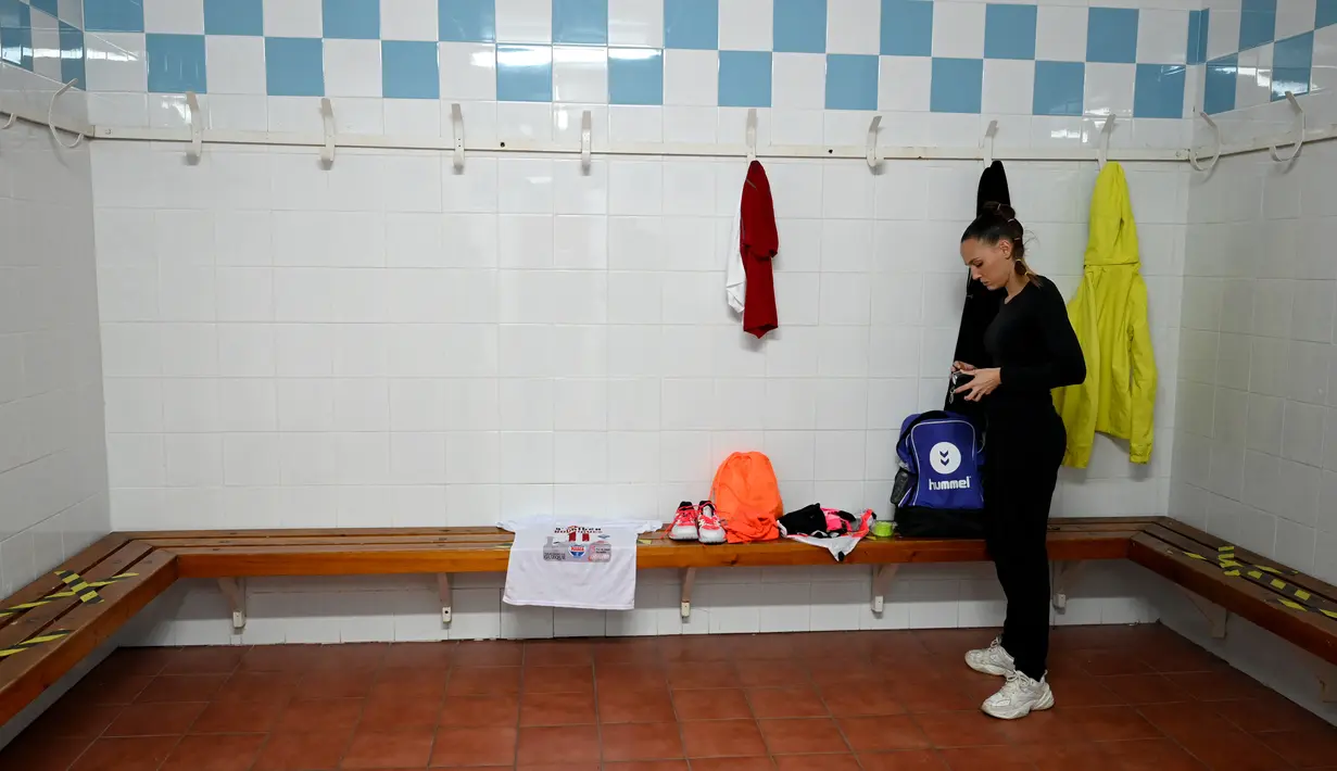 Pemain Spanyol Club Balonmano Albacete, Mireia Rodriguez bersiap-siap di ruang ganti pribadinya sebelum pertandingan pertamanya melawan Cabanillas di Albacete pada 6 November 2021. Mireia Rodriguez adalah wanita pertama yang bergabung dengan tim bola tangan pria profesional. (GABRIEL BOUYS / AFP)