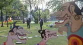 Pengunjung mengamati karya dalam pameran seni rupa kontemporer luar ruang Jakarta Provoke! di Taman Menteng, Jakarta Pusat, Jumat (17/7/2026). Pameran gratis yang berlangsung hingga 26 Juli 2026 ini menghadirkan 25 karya dari 25 seniman dan kolektif tentang dinamika kehidupan Jakarta. (KLY/Budy Santoso)