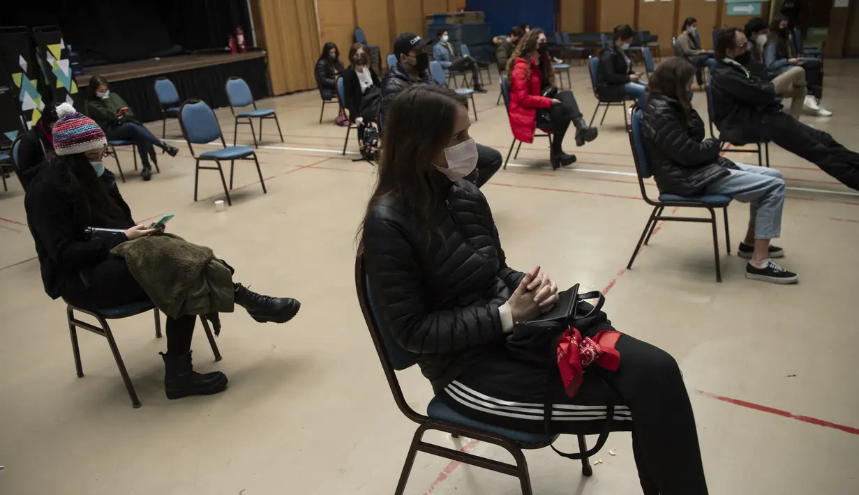 Anak-anak menunggu observasi seusai setelah diinokulasi dengan vaksin COVID-19 Pfizer BioNTech di pusat vaksinasi di Santiago, Chile, Rabu (23/6/2021). Chile mulai memvaksinasi anak-anak dari usia 12 tahun, sebagai salah upaya memutus rantai penyebaran infeksi virus Corona. (MARTIN BERNETTI/AFP)