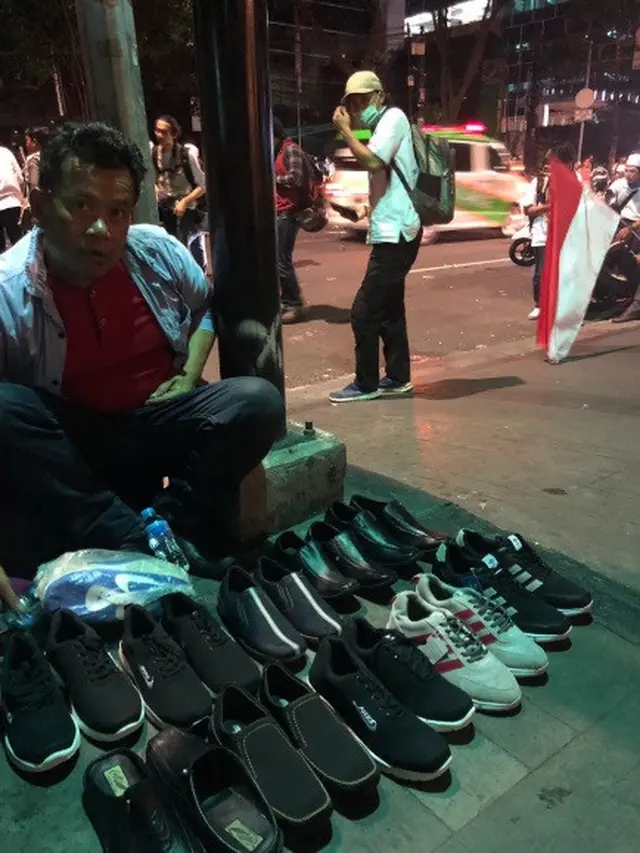 pria ini tetap berjualan sepatu saat demo