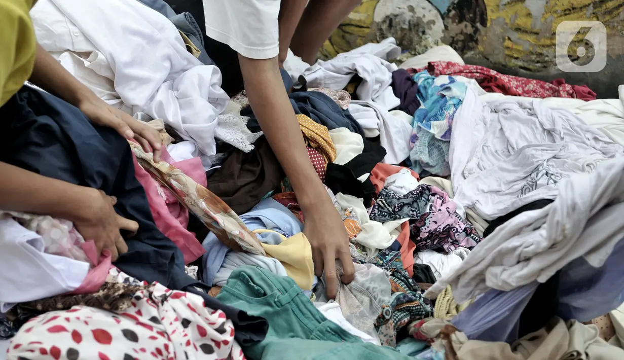Pakaian sumbangan yang ditempatkan di pinggir Kali Ciliwung, Kampung Pulo, Jakarta Timur, Senin (6/1/2020). Banjir menyebabkan ratusan warga di Kampung Pulo kehilangan pakaian akibat rusak dan hanyut. (merdeka.com/Iqbal S. Nugroho)