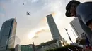 Seorang pilot drone saat menerbangkan drone di Bundaran HI, Jakarta, Kamis(28/5/2015). Penggunaan pesawat terbang tanpa awak atau yang sering disebut sebagai drone mulai dilarang di beberapa negara. (Liputan6.com/Faizal Fanani)