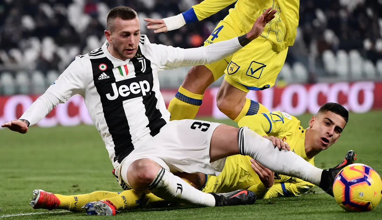 Pemain Juventus Federico Bernardeschi dan pemain Chievo Sofian Kiyine berebut bola pada laga pekan ke-20 Serie A di Allianz Stadium, Senin (21/1). Juventus berhasil memantapkan posisi di puncak klasemen setelah menggilas Chievo 3-0. (Marco BERTORELLO/AFP)