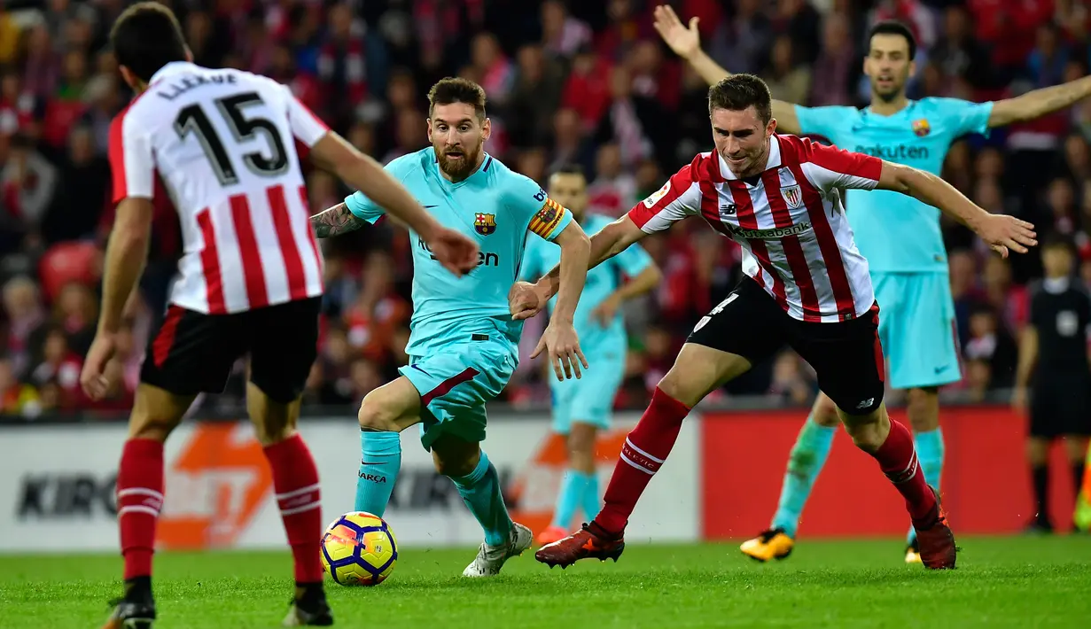 Pemain Barcelona, Lionel Messi menggiring bola dengan kawalan pemain Athletic Bilbao pada pekan ke-10 Liga Spanyol di San Mames, Minggu (29/10) dini hari. Satu gol dari Messi dan Paulinho membawa Blaugrana menang 2-0. (AP/Alvaro Barrientos)
