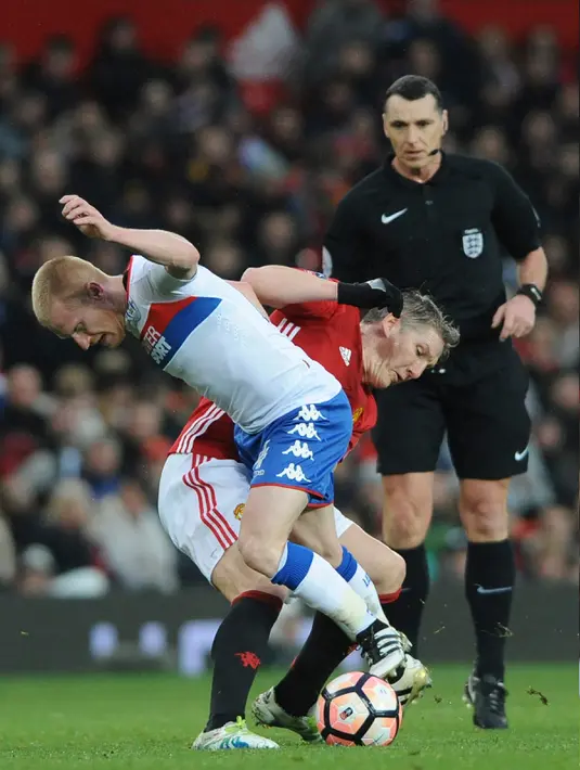 Gelandang MU, Bastian Schweinsteiger berebut bola dengan gelandang Wigan Athletic, David Perkins pada pertandingan Piala FA di Stadion Old Trafford, Inggris (29/1). Manchester United  melaju ke babak 16 besar Piala FA. (AP Photo/Rui Vieira)