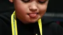 Seorang anak laki-laki serius memecahkan permainan rubik pada kejuaraan kubus Rubik Dunia di Melbourne, Australia (12/7/2019). Permainan Kubus Rubik 3x3x3, ditemukan oleh Profesor Rubik dari Hongaria pada tahun 1974. (AFP Photo/William West)