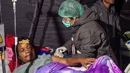 Para korban gempa bumi mendapatkan perawatan di tenda medis darurat di depan Rumah Sakit Ruteng di Ruteng, Manggarai, Nusa Tenggara Timur, Sabtu malam, 15 Agustus 2025. (AFP/ Juni Kriswanto)