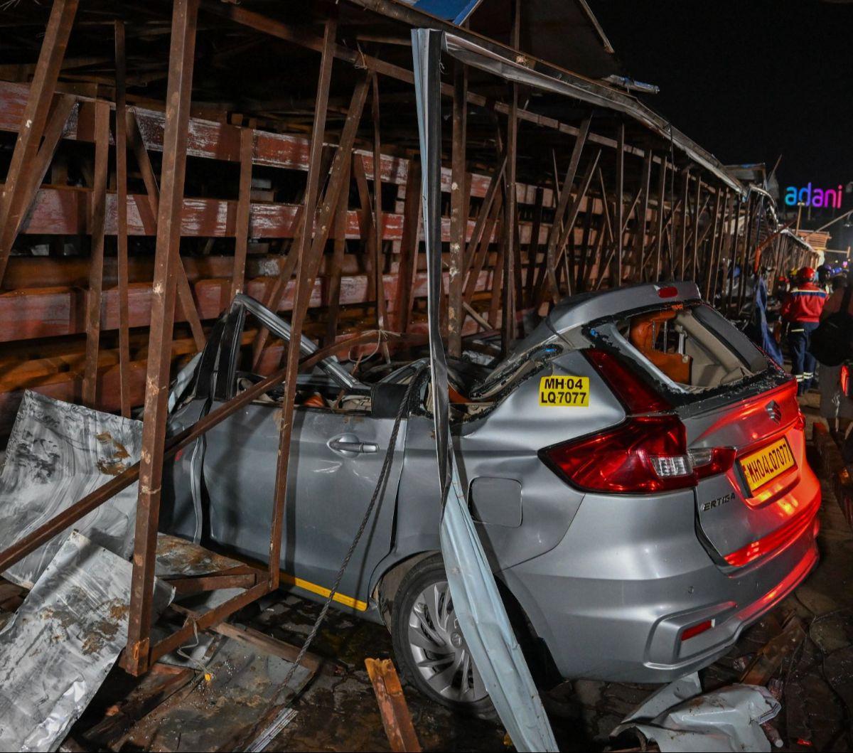 Kondisi sebuah mobil yang rusak berat setelah tertimpa papan reklame raksasa di Mumbai, India, pada 13 Mei 2024. Sebanyak 14 orang dilaporkan tewas ketika terjangan badai menyebabkan sebuan papan reklame raksasa runtuh.&nbsp;Foto: Punit Paranjpe/AFP