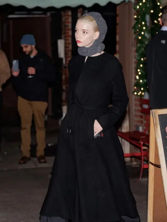 Anya Taylor-Joy, yang tampak berjalan terpisah dari rombongan, terlihat mengenakan penutup kepala, mantel hitam besar, dan sepasang sepatu hak berkilau untuk acara tersebut. [Foto: IG/@thehapablonde]