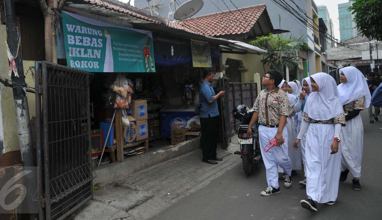 Siswa SMP N 104 Jakarta mengamati banner di salah satu warung di kawasan Mampang Prapatan, Jakarta, Kamis (5/11). Aksi ini sebagai bentuk kesadaran tentang ancaman adiksi rokok terhadap anak-anak di sekolah melalui iklan (Liputan6.com/Gempur M Surya)
