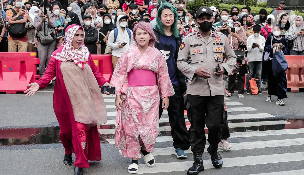 Evelyn Nada Anjani dan DJ nomor satu di Jepang, DJ Shacho berpose menampilkan busananya di atas zebra cross di kawasan Dukuh Atas, Jakarta, Selasa (26/7/2022). Evelyn dan DJ Shacho ikut meramaikan fenomena Citayam Fashion Week dengan tampil mengenakan busana khas negeri Sakura, Jepang. (Liputan6.com/Faizal Fanani)