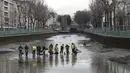 Sejumlah petugas kebersihan memindahkan ikan menggunakan jala di Kanal Saint Martin, Paris selama proses pengeringan dan pembersihan. (06/1/2016) (AFP PHOTO / PATRICK KOVARIK)