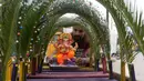 Seorang perajin memajang patung Dewa Ganesha untuk dijual di kios pinggir jalan di Hyderabad, India, Kamis (9/9/2021). Patung dewa Hindu berkepala gajah tersebut banyak dijual jelang Festival Ganesh Chaturthi. (NOAH SEELAM/AFP)