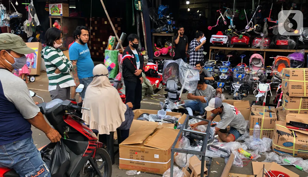 Warga memilih mainan tanpa menjaga jarak di Pasar Gembrong, Jakarta Timur, Minggu (31/5/2020). Meski penerapan masa Pembatasan Sosial Berskala Besar (PSBB) di Jakarta masih berlaku, namun pasar yang khusus menjual pernak-pernik mainan anak ini kembali dipadati warga. (Liputan6.com/Immanuel Antonius)