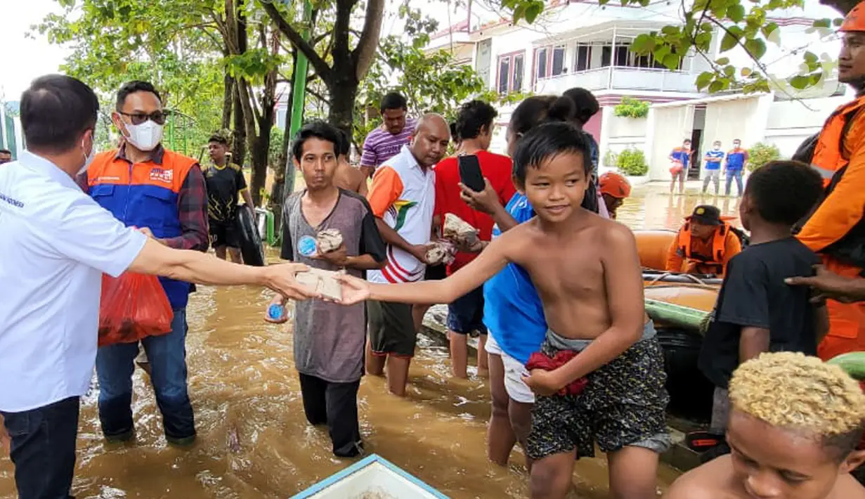 Sejumlah karyawan BRI membagikan paket makanan siap saji kepada masyarakat terdampak banjir di Abepura, Jayapura, Papua. Penyaluran bantuan dilakukan secara bertahap dengan memprioritaskan masyarakat yang terdampak lebih parah. (Liputan6.com/HO/Humas BRI)