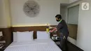 Petugas hotel menyemprotkan cairan disinfektan di kamar isolasi mandiri Hotel Grand Whiz Poins Simatupang, Jakarta, Kamis (16/4/2020). Selama 14 hari petugas melakukan penyemprotan bagi tamu yang mengambil paket isolasi mandiri selama pandemi Corona (Covid-19). (Liputan6.com/Fery Pradolo)