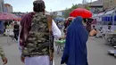 <p>Seorang perempuan mengenakan burqa berjalan melalui pasar lama ketika Taliban berjaga-jaga, di pusat kota Kabul, Afghanistan, 8 Mei 2022. Taliban memerintahkan perempuan Afghanistan untuk mengenakan pakaian dari kepala hingga ujung kaki atau burqa tradisional di depan umum. (AP Photo/Ebrahim Noroozi)</p>
