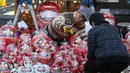 Pedagang boneka merah Daruma dalam pameran tahunan Oume Daruma di Tokyo, Jepang, 12 Januari 2018. Boneka Daruma ini merupakan pembawa keberuntungan dan lambang harapan yang belum tercapai. (AP/Koji Sasahara)