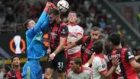 Kiper Benfica Anatoliy Trubin menghalau sundulan pemain AC Milan Strahinja Pavlovic dalam laga Liga Europa antara AC Milan vs Benfica di Milan, Italia, Rabu, 16 September 2026. (AP Photo/Antonio Calanni)