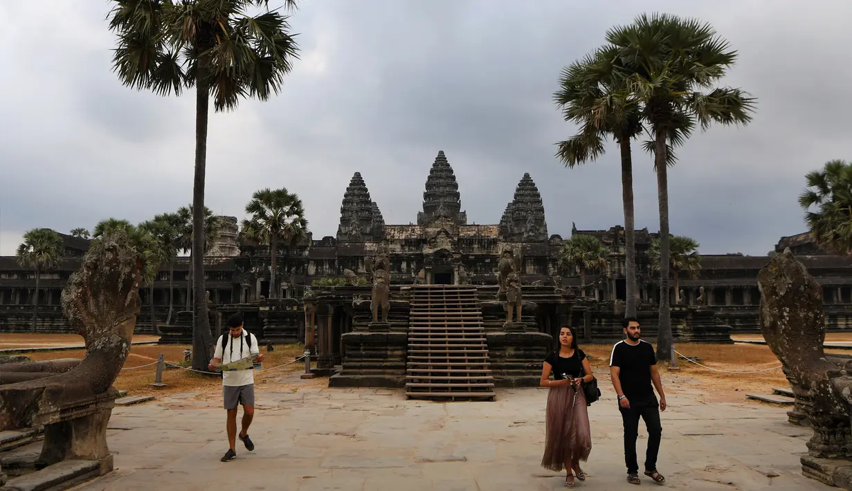 Sejumlah wisatawan berjalan di Candi Angkor Wat, Provinsi Siem Reap, Kamboja, Kamis (5/3/2020). Menurut World Travel and Tourism Council, wabah virus corona (COVID-19) membuat sektor pariwisata dunia kehilangan USD 22 miliar. (TANG CHHIN Sothy/AFP)
