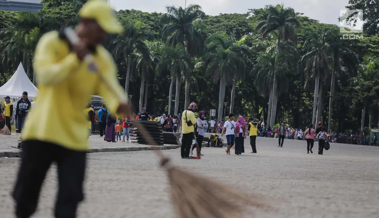 Petugas menyapu membersihkan kawasaan Monas, Jakarta, Senin (1/1). Sebelumnya, kawasan Monas menjadi titik berkumpul warga saat perayaan malam pergantian tahun dan menyisahkan sampah dari pengunjung monas. (Liputan6.com/Faizal Fanani)