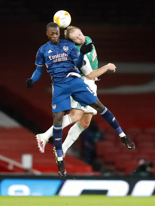 Pemain Arsenal Nicolas Pepe (kiri) dan pemain Rapid Wien Mario Sonnleitner melakukan sundulan pada pertandingan Grup B Liga Europa di Emirates Stadium, London, Inggris, Kamis (3/12/2020). Arsenal menyegel status juara Grup B Liga Europa usai menaklukkan Rapid Wien 4-1. (AP Photo/Frank Augstein)