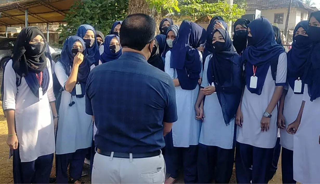 Sejumlah siswi berbicara dengan kepala sekolah mereka di luar kampus di Udupi, India, Jumat, 4 Februari 2022. Sejumlah sekolah di negara bagian Karnataka di India melarang para siswi memakai hijab di dalam kelas. (Bangalore News Photos via AP)