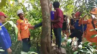 Petugas Badan Penanggulangan Bencana Daerah (BPBD) Kabupaten Belitung turun tangan membantu melepaskan kaki sang anak yang terjepit di sela-sela batang pohon. (Liputan6.com/ Dok Ist BPBD Belitung)