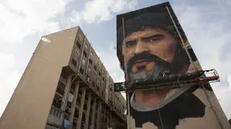 Mural legenda sepak bola, Diego Armando Maradona yang digambar di sebuah tembok pemukiman warga di San Giovanni a Teduccio, Italia (28/2). Jorit Agoch dikenal sebagai seniman mural hyper-realistis. (AFP/Renato Esposito)