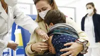 Seorang anak memeluk ibunya setelah menerima suntikan vaksinasi COVID-19 untuk anak-anak usia 5-11 di Roma, Rabu (16/12/2201). Italia mulai memvaksinasi anak-anak berusia 5-11 tahuns aat pemerintah bersiap menghadapi penyebaran varian omicron selama musim liburan. (Cecilia Fabiano/LaPresse via AP)