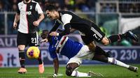 Striker Juventus, Cristiano Ronaldo, terjatuh saat berebut bola dengan bek Sampdoria, Omar Colley pada laga Serie A 2019 di Stadion Luigi Ferraris, Rabu (18/12). Juventus menang 2-1 atas Sampdoria. (AFP/Marco Bertorello)
