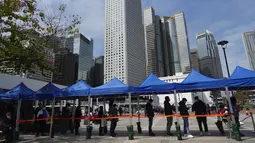 Warga antre tes virus corona di pusat pengujian sementara di Hong Kong, 23 Februari 2022. Warga Hong Kong menjadi semakin terganggu dengan desakan pemerintah untuk tetap berpegang pada strategi "nol-COVID" ketika kota itu mencatat rekor jumlah kasus baru lainnya pada hari Rabu. (AP Photo/Vincent Yu)
