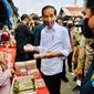 Presiden Joko Widodo (Jokowi) didampingi Menteri BUMN Erick Thohir membagikan bantuan langsung tunai (BLT) kepada para pedagang di Pasar Baru Tanjung Enim, Kabupaten Muara Enim, Sumatra Selatan, Senin (24/1/2022). Bantuan yang diberikan sebesar Rp1,2 juta per orang. (Dok. Biro Pers Kepresidenan)